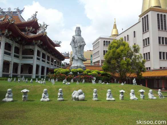 Statue de Guanyin et Bouddhas dans l'herbe